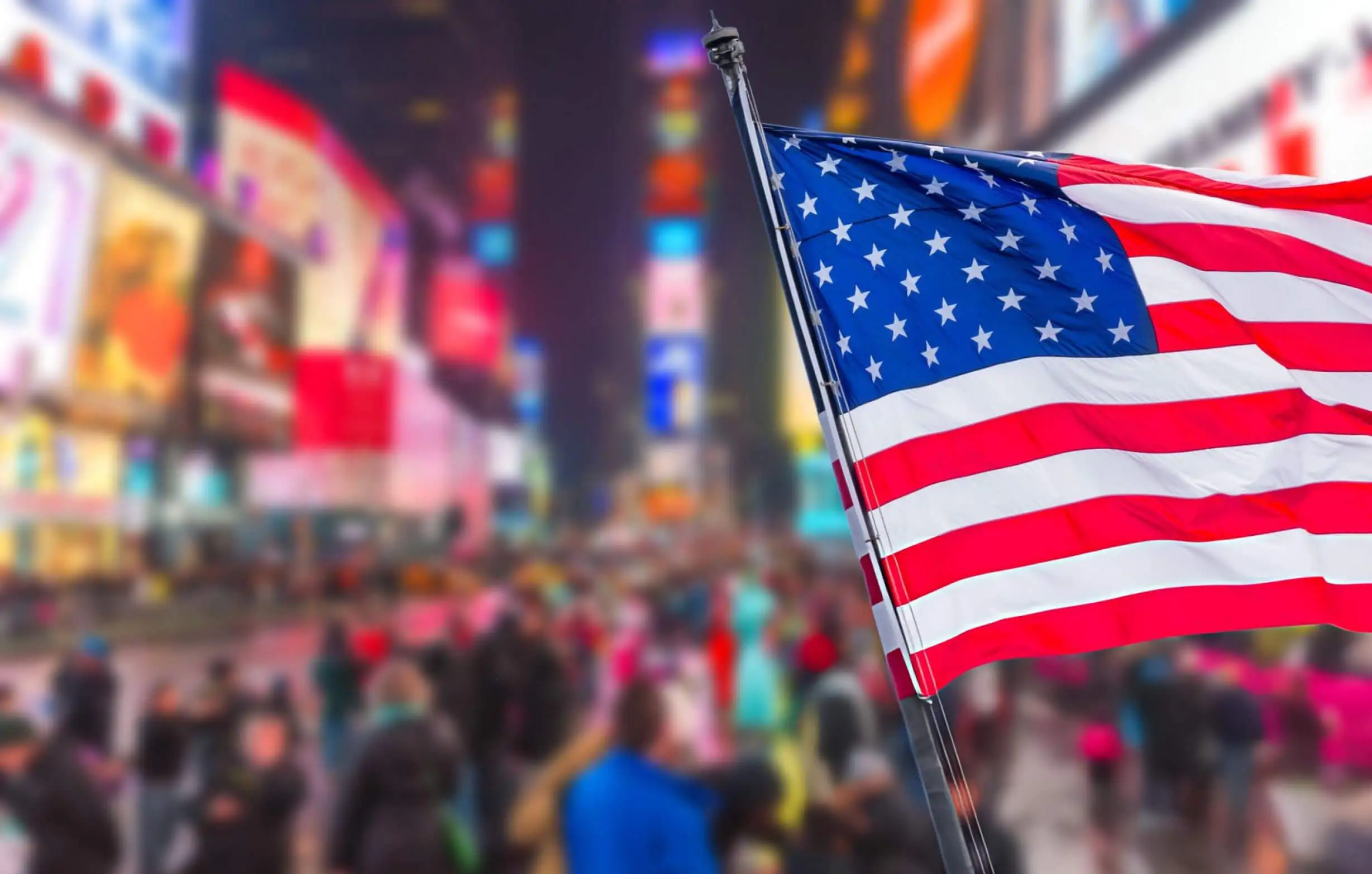 USA national flag on Times Square street with huge blured crowd